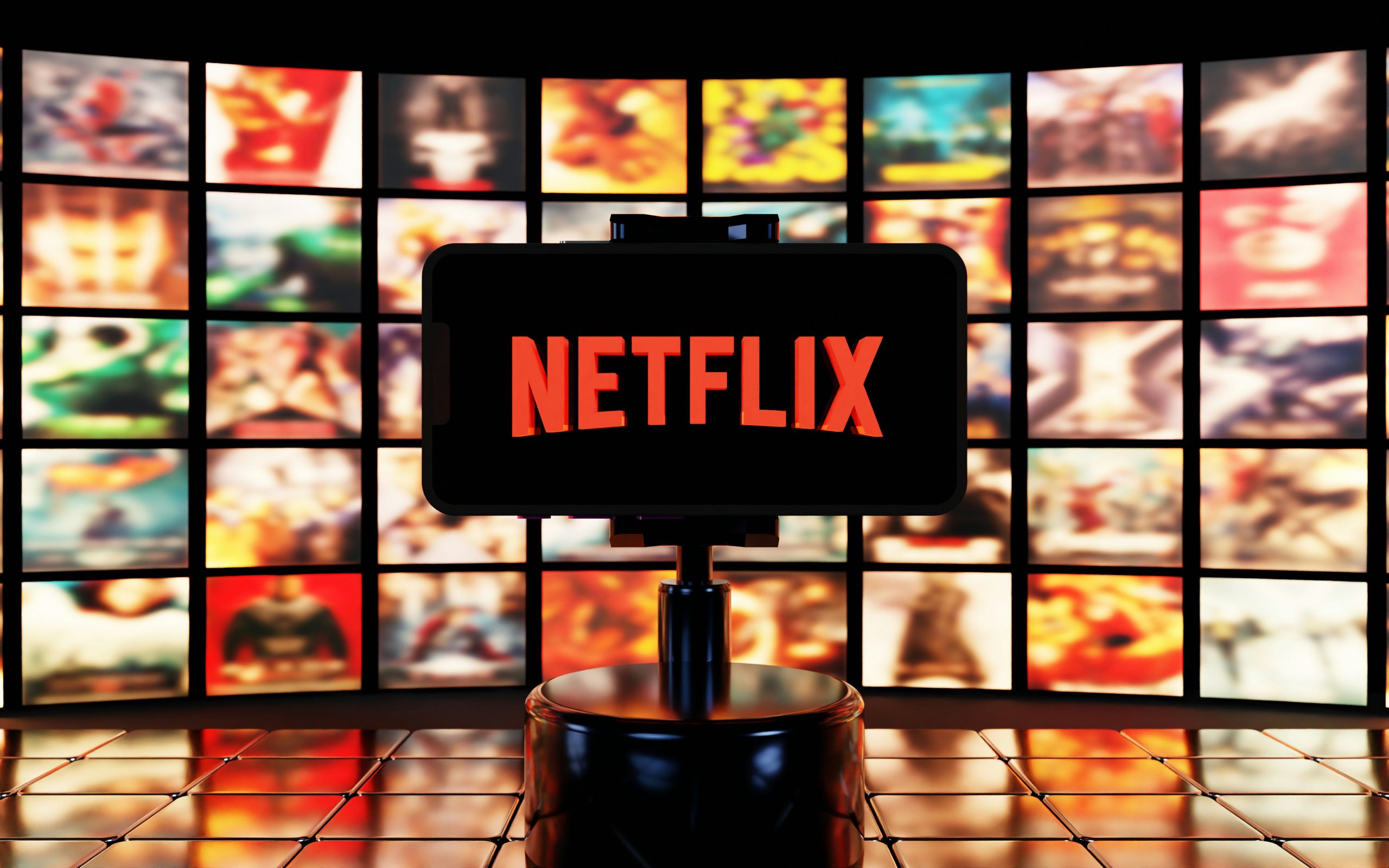 Netflix promotional image with the logo on a pedestal against a background of many movie posters